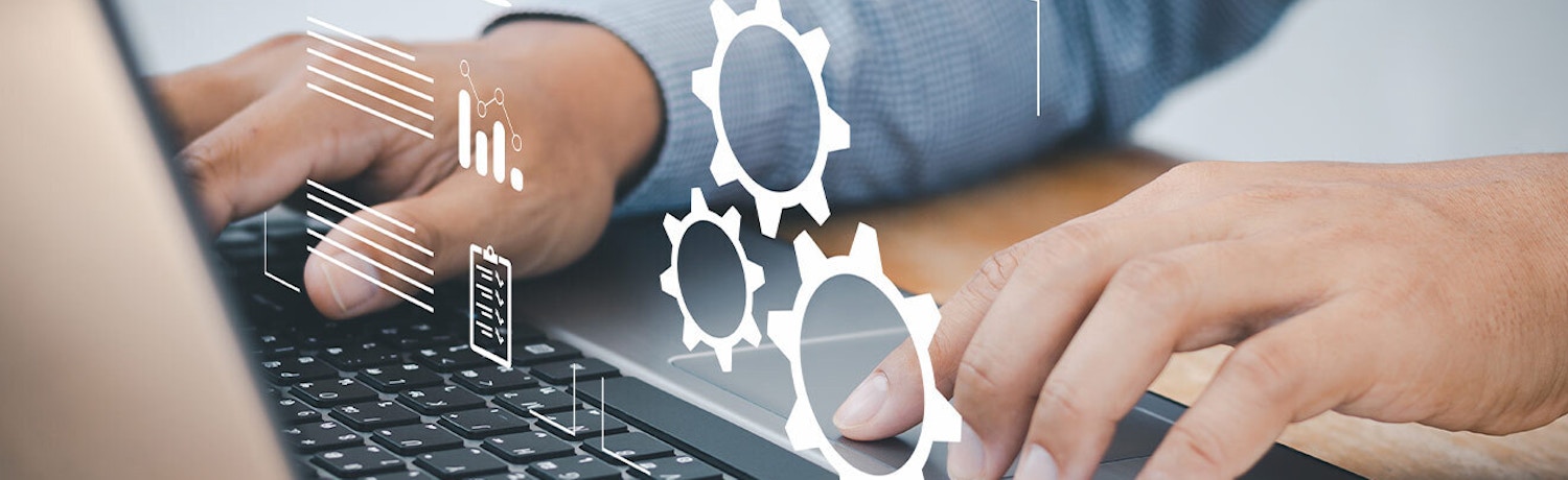 AI vs Automation: Key Differences in Modern Technology Hands typing on a laptop with virtual gear icons and analytics overlays, symbolizing the contrast between AI and automation technologies.